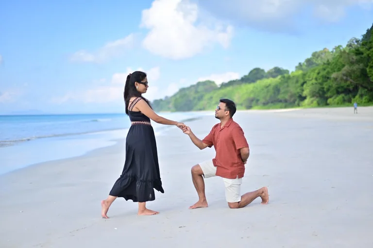 A couple sharing a celebratory moment on an Andaman beach with Regal Reef Andamans