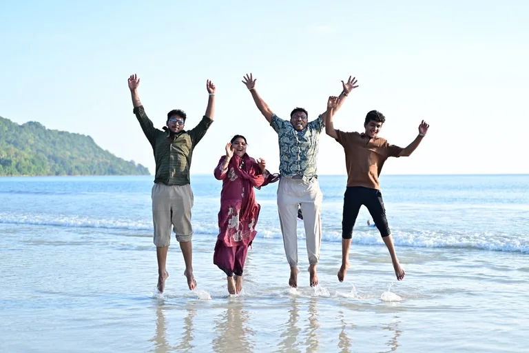 A family group jumping together on a sunny Andaman beach