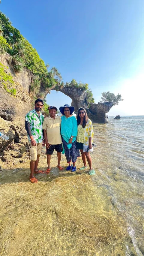 A family group visiting a natural coastal rock formation