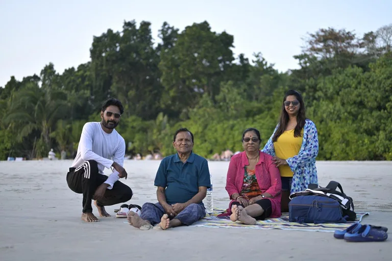 A family group sharing a relaxed picnic beside the beach