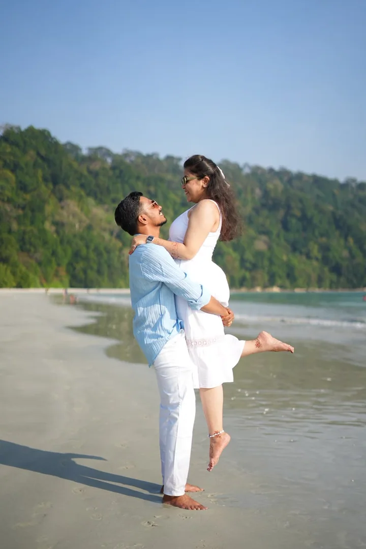 A couple sharing a playful moment beside the Andaman Sea