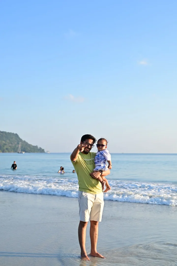 A parent and young child sharing a happy beach moment